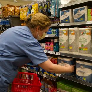 A person wearing scrubs shops at the 7-11 hospital pop-up store
