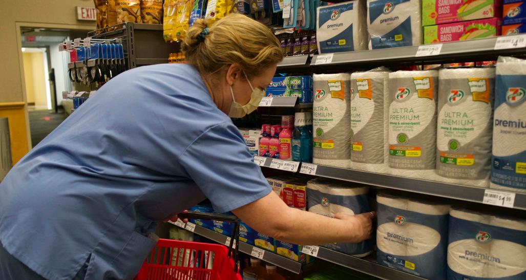 A person wearing scrubs shops at the 7-11 hospital pop-up store