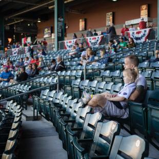 A father and his daughter enjoy a sports game together