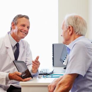 doctor and patient smile and look at screen together during visit