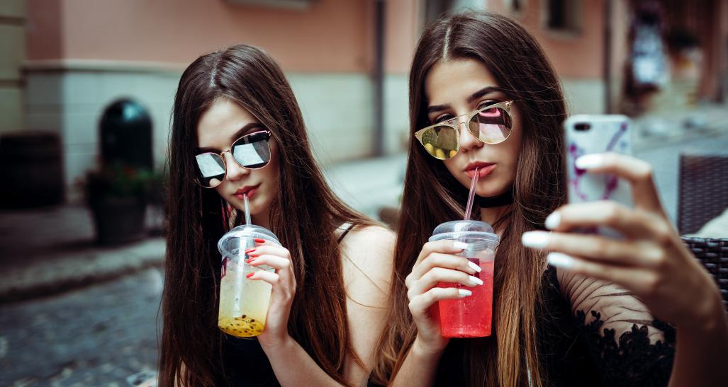 Teenage girls with drinks taking a selfie