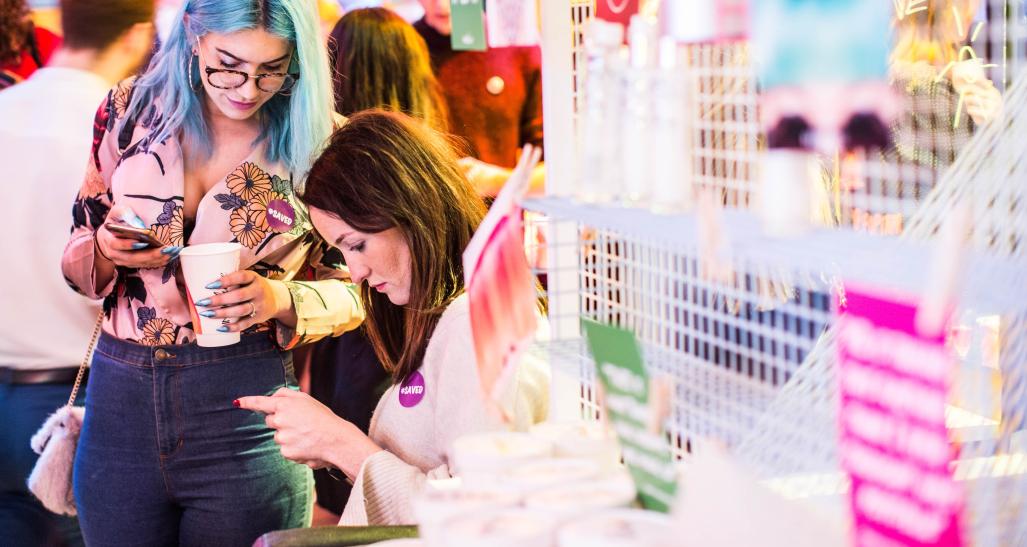 Two gen z women hanging out at an arcade on their phones