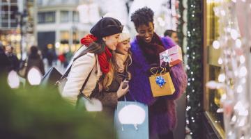 two girls are looking at their holiday gifts during the holiday season