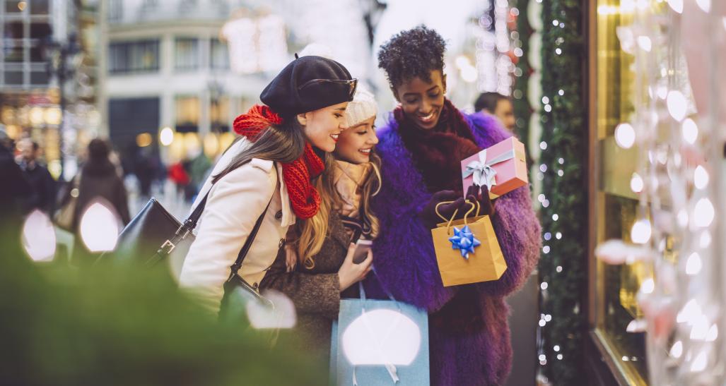 two girls are looking at their holiday gifts during the holiday season