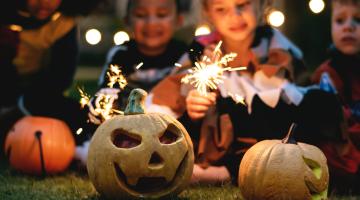 Kids with fireworks and Halloween carved pumpkins