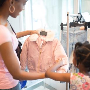 Mother and child look at coat in a store