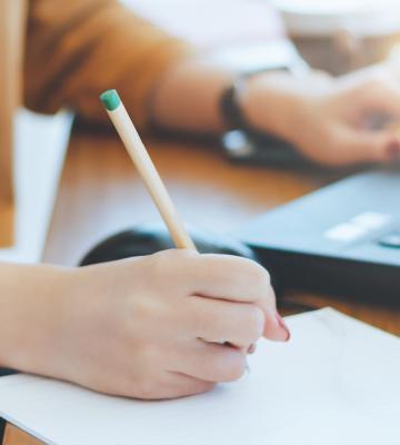 Woman takes notes at laptop