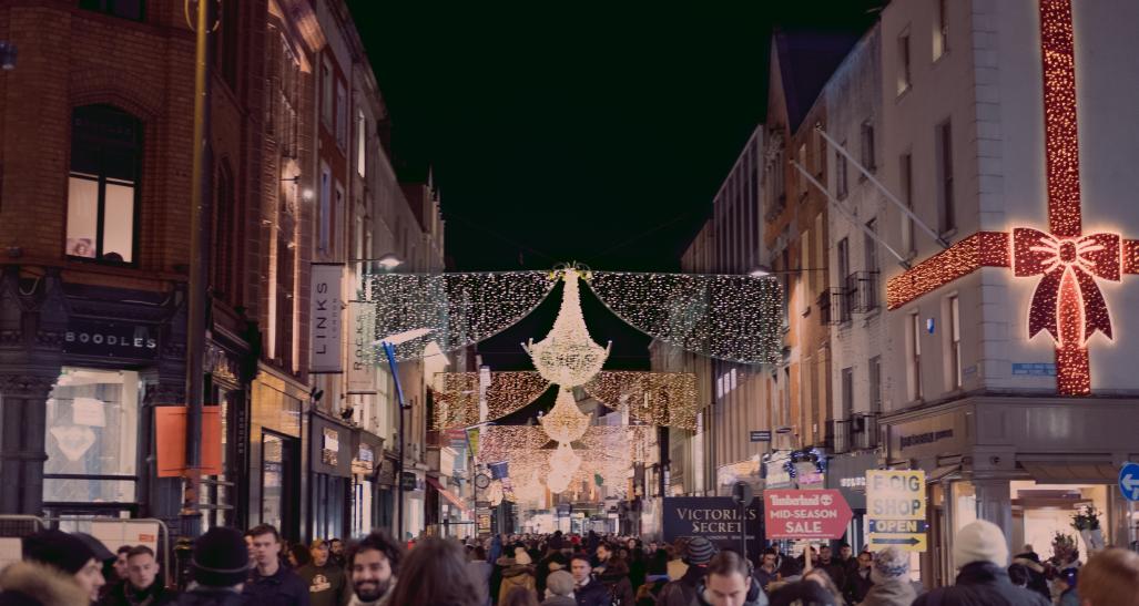 Hundreds of people shop at a busy outdoor mall during the holiday season