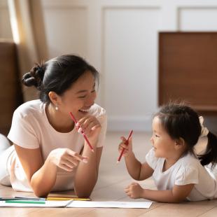 Mother draws with daughter on the floor on Mother's Day