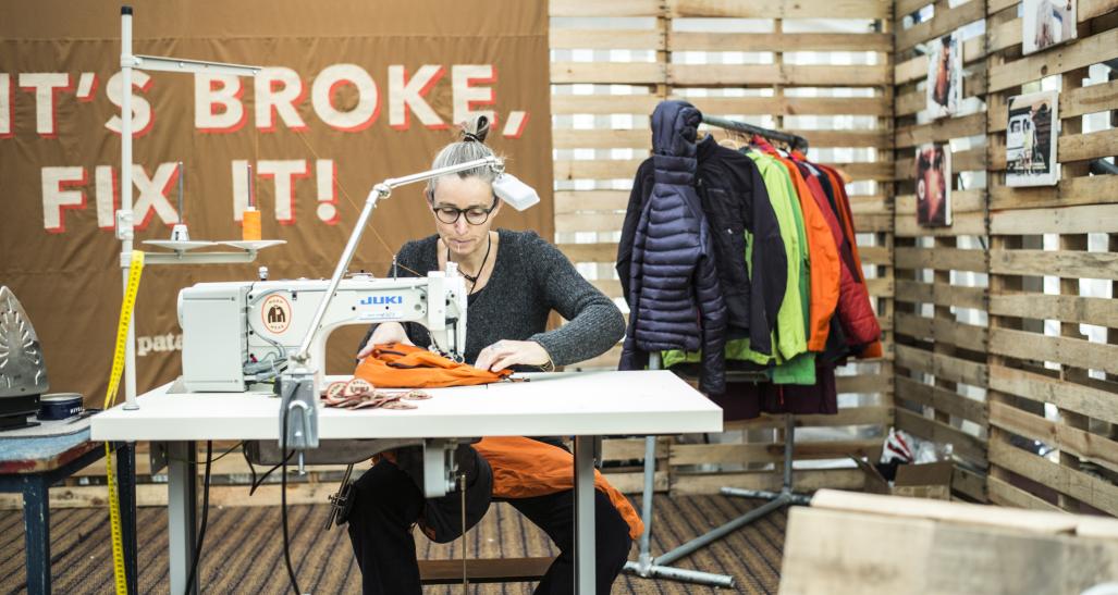 Woman restoring garments for a resale program.