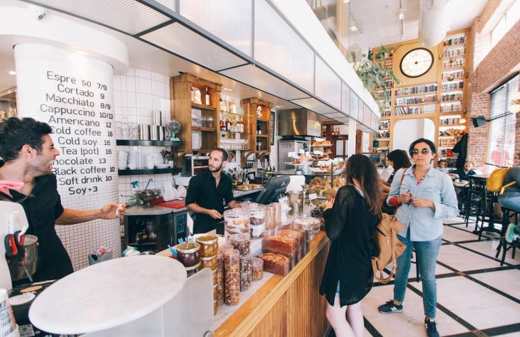 a busy coffee shop with customers waiting around