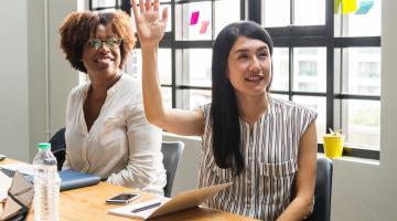 Woman raising her hand in a meeting