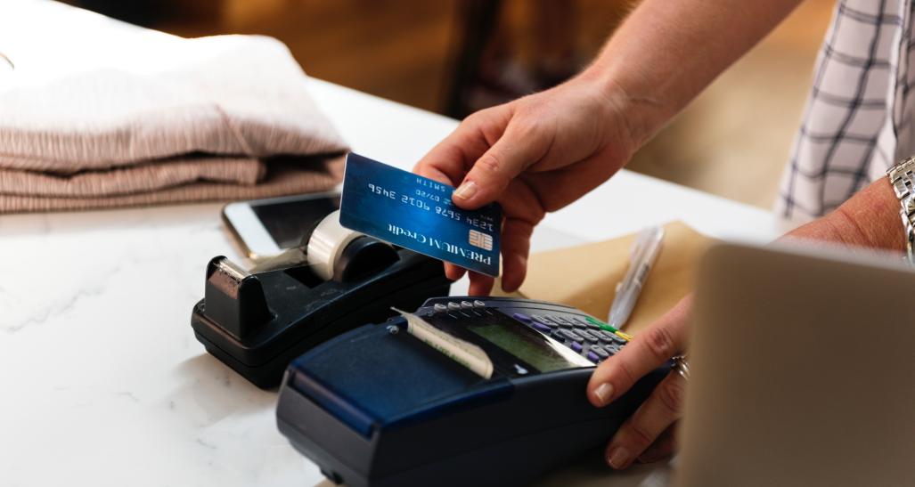 A customer swipes his credit card to purchase something at a store
