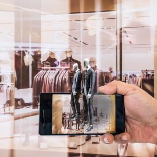 A person holds their phone using the augmented reality feature at a store