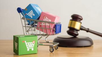 A shopping cart and gavel symbolizing retail law. 