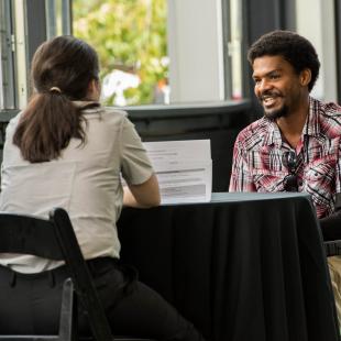 A woman interviews a man at the NRF Foundation Rise-Up event