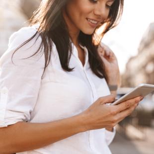 woman looks at her phone on the street