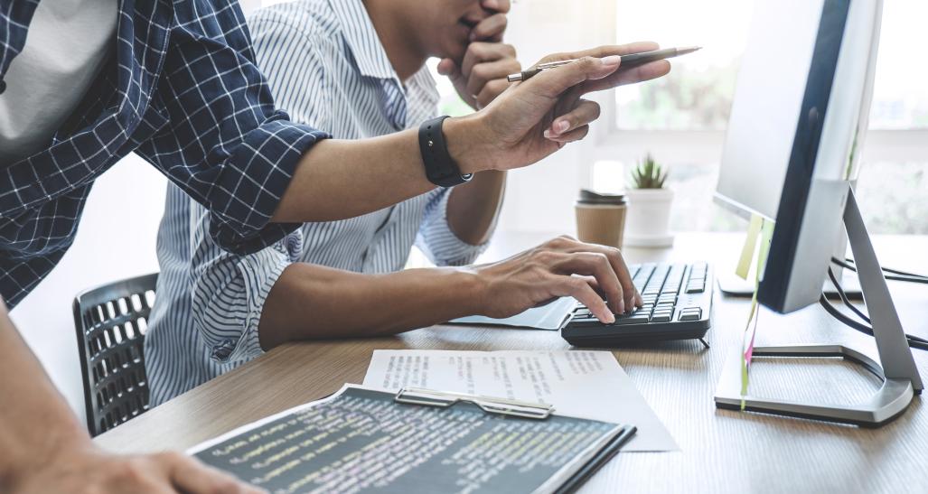 Two men work on computers