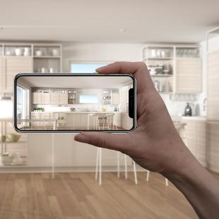 A person holds up a smartphone in their home