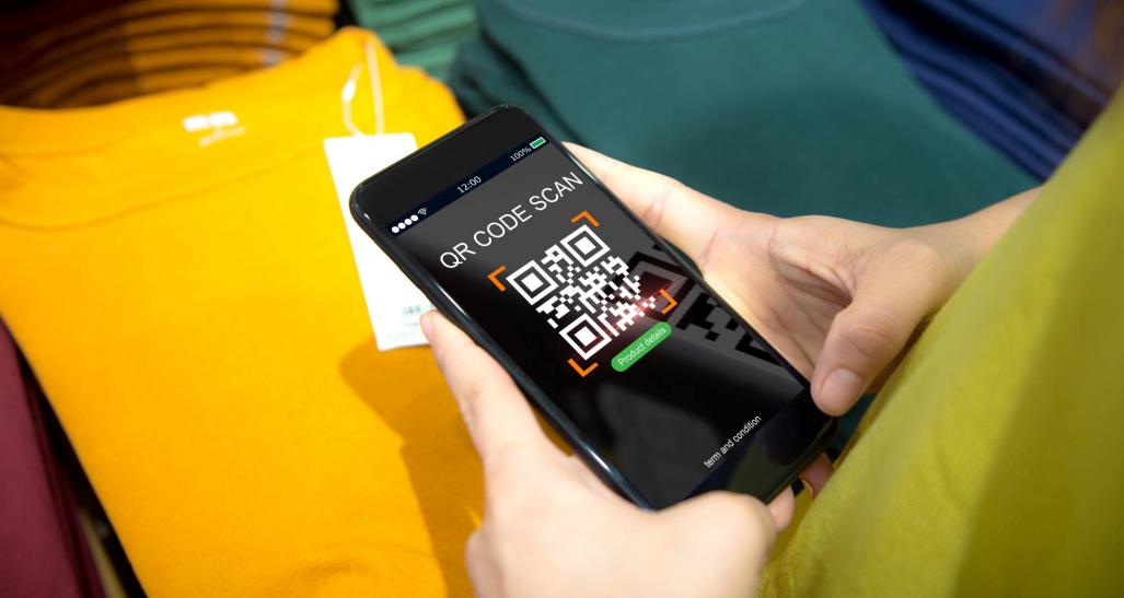Woman scans a QR code on a clothing label while shopping