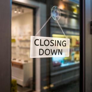 A closing down sign displayed in a window.