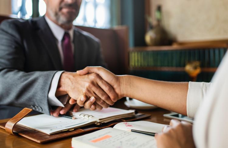 a man and a woman are shaking hands at a table