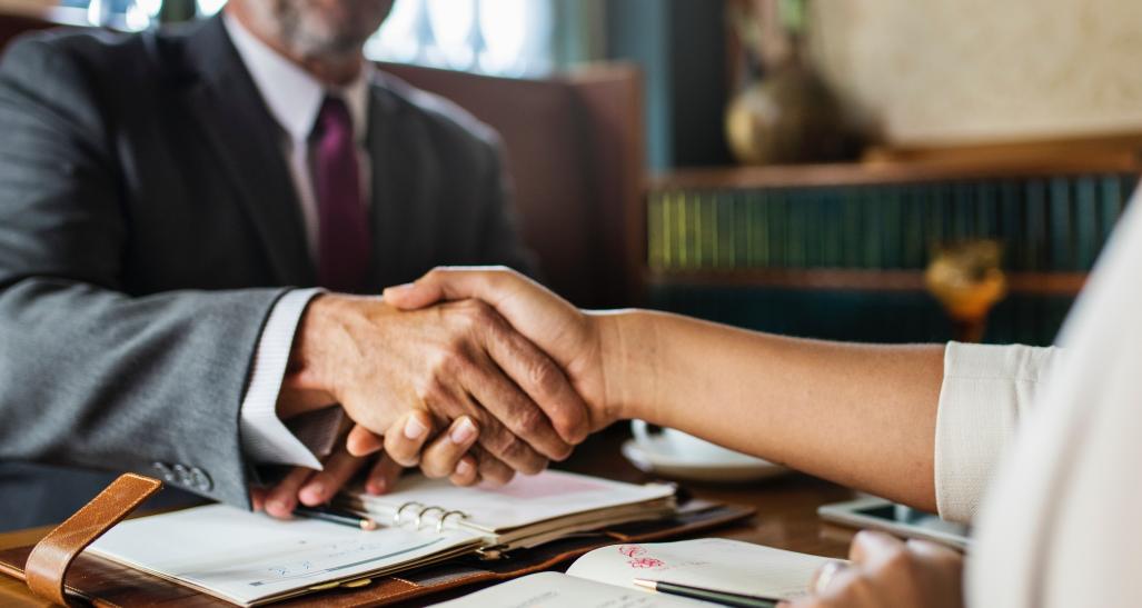 a man and a woman are shaking hands at a table