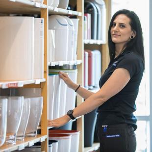 Woman next to retail shelf with products
