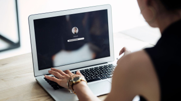 A woman is logging into her macbook