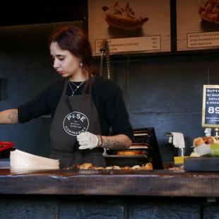 A woman is working in the kitchen at a restaurant 