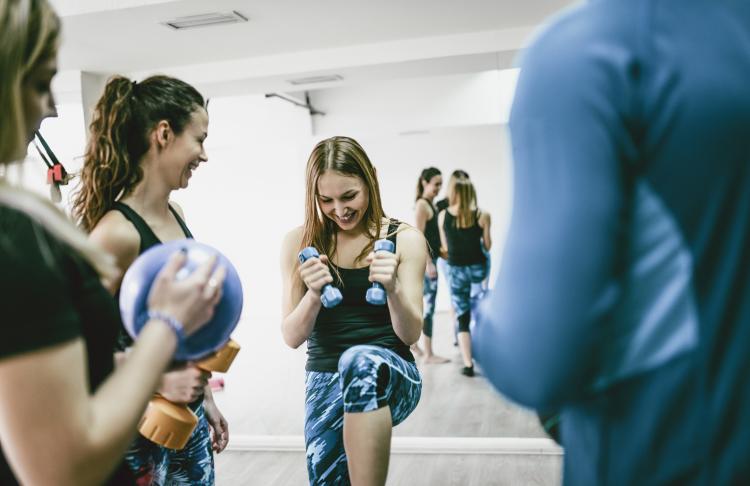 a group of women workout together at the gym