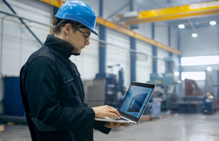 manufacturer worker checking engineering file on a laptop