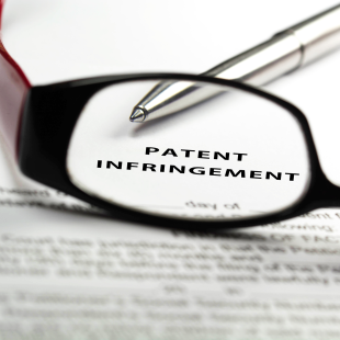 patent infringement paperwork with glasses and pen