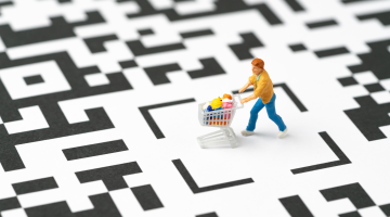 figure of a shopper pushing a cart over a QR code